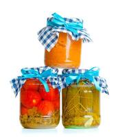 Canned vegetables in glass jars isolated on white background photo