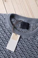 Stack of wool knitted warm sweater and white label for text photo