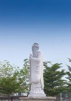 Confucius sculpture Located in the middle of tall green trees photo