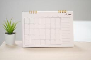 Desk calendar for June on the table with copy space in work space concept. photo