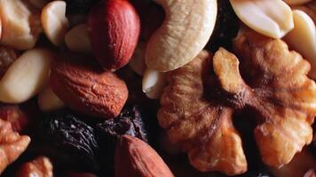 Mixed Nuts. Almonds, Walnuts, Cashews, Peanuts, Hazelnuts, Dried Prunes and Raisins - Rotating, Top View. Different Nut Mix Turning. Background from Various Nuts and Dried Fruits - Rotation video