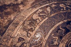 An ancient stone carving with intricate animal designs and patterns photo