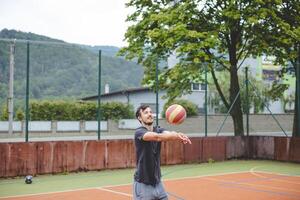Volleyball player executing a bump pass on a hard court during an outdoor practice session. The action captures focus, movement, and ball control in a casual game setting photo