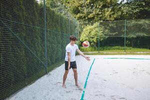 Volleyball player practicing a bump pass on a sand court, focusing on technique and control. Captured in an outdoor setting, showcasing beach volleyball skills and training photo