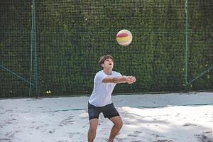 Volleyball player passing a ball on a sand court, focusing on precise ball control and technique. Captured during an intense outdoor game of beach volleyball photo