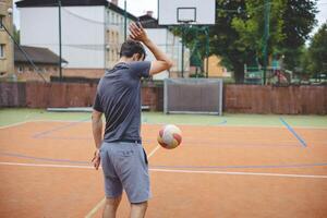Volleyball player practicing ball control on a hard court, focusing on precision and movement during an outdoor training session. Captured in a calm, focused moment photo