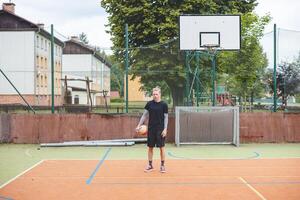 Volleyball player standing on a hard court, holding a ball with focus and determination before the game. The image captures a calm moment of preparation in an outdoor volleyball setting photo