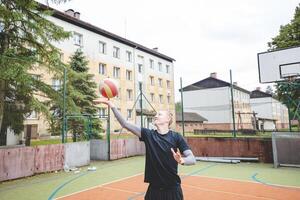 Volleyball player standing on a hard court, bouncing the ball while preparing for the next play during an outdoor game. A calm, focused moment before the action begins photo