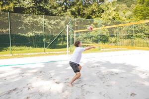 Volleyball player passing a ball on a sand court, focusing on precise ball control and technique. Captured during an intense outdoor game of beach volleyball photo