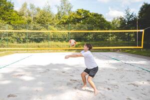 Volleyball player passing a ball on a sand court, focusing on precise ball control and technique. Captured during an intense outdoor game of beach volleyball photo