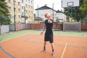 Volleyball player standing on a hard court, bouncing the ball while preparing for the next play during an outdoor game. A calm, focused moment before the action begins photo