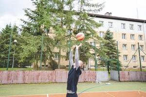 Volleyball player practicing setting the ball on a hard court, focusing on control and precision during an outdoor training session. A calm, focused moment in the game photo