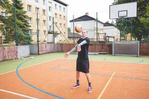 Volleyball player standing on a hard court, bouncing the ball while preparing for the next play during an outdoor game. A calm, focused moment before the action begins photo