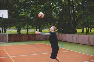 Volleyball player is passing on a hard court during an outdoor practice session. The action captures focus, movement, and ball control in a casual game setting photo