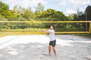 Volleyball player passing a ball on a sand court, focusing on precise ball control and technique. Captured during an intense outdoor game of beach volleyball photo