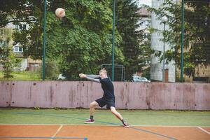 Volleyball player performing a digging on a hard court, focusing intently on the ball during an intense game. The action showcases skill, concentration, and athleticism photo