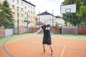 Volleyball player standing on a hard court, bouncing the ball while preparing for the next play during an outdoor game. A calm, focused moment before the action begins photo