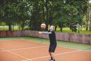 Volleyball player is passing on a hard court during an outdoor practice session. The action captures focus, movement, and ball control in a casual game setting photo