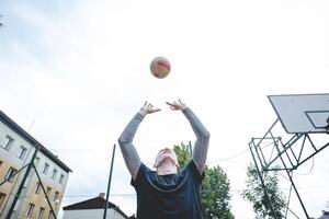 Volleyball player practicing setting the ball on a hard court, focusing on control and precision during an outdoor training session. A calm, focused moment in the game photo