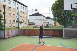Volleyball player is passing on a hard court during an outdoor practice session. The action captures focus, movement, and ball control in a casual game setting photo