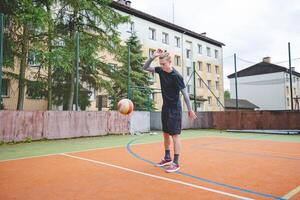 Volleyball player standing on a hard court, bouncing the ball while preparing for the next play during an outdoor game. A calm, focused moment before the action begins photo