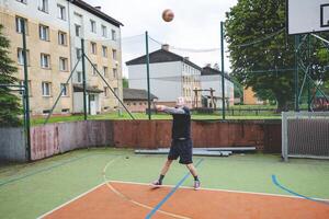 Volleyball player is passing on a hard court during an outdoor practice session. The action captures focus, movement, and ball control in a casual game setting photo
