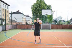 Volleyball player standing on a hard court, bouncing the ball while preparing for the next play during an outdoor game. A calm, focused moment before the action begins photo