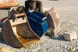 Dirty excavator buckets standing on a construction site. photo