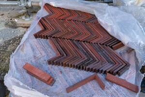 A collection of red corner bricks is neatly arranged in a zigzag photo