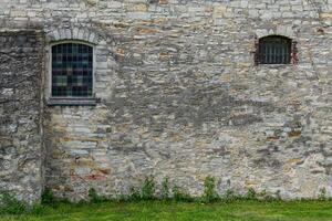 Fragment of a gray stone wall with arched windows. photo