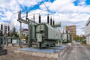 A large stationary electrical transformer against a cloudy sky. photo