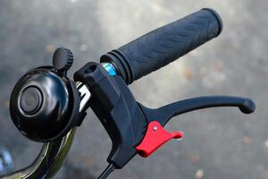 Part of a bicycle handlebar with handbrake and bell. photo