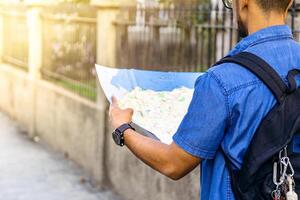 man from behind looking at a map looking for a location. travel and tourism concept. photo