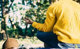 unrecognizable man sitting in a forest doing meditation posture. vacation and mental health concept. photo
