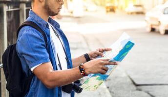 man from behind looking at a map looking for a location. travel and tourism concept. photo