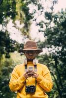 Young man traveler in a green forest, checking his mobile phone. communication concept. photo