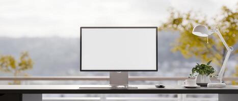 A close-up of a PC computer on a black table in a bright minimalist room with a view from a balcony photo