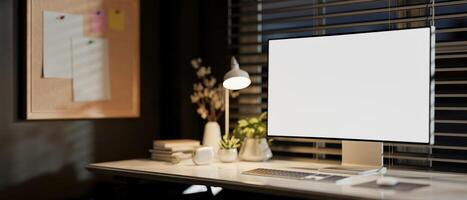 A computer on a desk against the window in a modern white office at night. photo