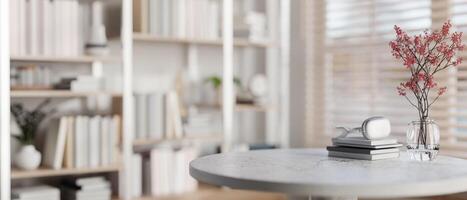 A space for displaying products on a round table with a large bookshelf in the background. photo
