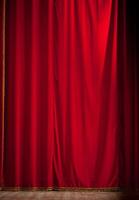 A red curtain is open in front of a wooden floor photo