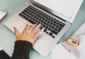 Woman working with laptop computer at home. Smart working concept. photo