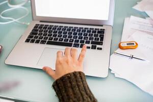 Woman working with laptop computer at home. Smart working concept. photo