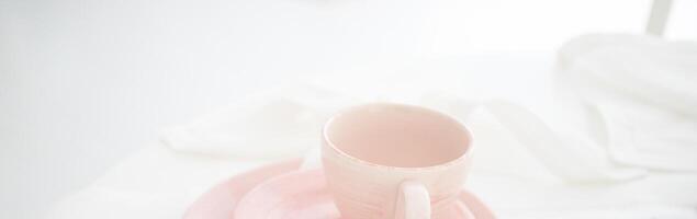 Tender pink mug on light background. Ceramic coffee cup for montage or design. photo