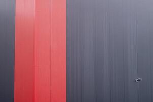 Red and gray corrugated metal wall creating modern abstract design photo