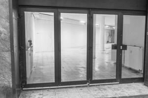 Empty commercial space seen through glass doors with tiled floor photo