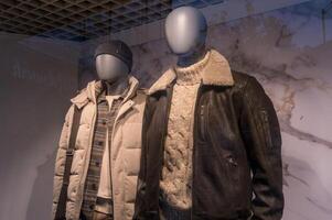 Mannequins wearing winter jackets and sweater in a fashion retail store display photo