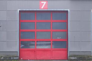 Red garage door number seven on gray building photo