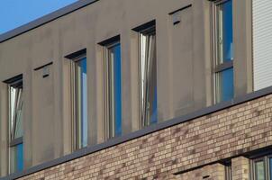 Modern building exterior with open windows and brick facade photo