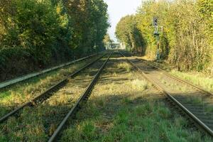 Railroad tracks disappearing into the distance on sunny autumn day photo