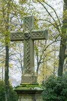 Stone cross standing in cemetery representing faith and remembrance photo